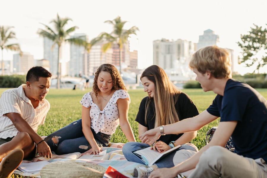 students from the christian community development program sit on a blanket reading